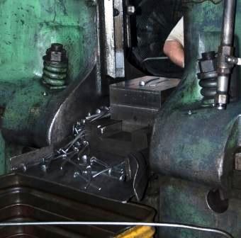 After forging, holes are created in the pliers parts by a large punch press.