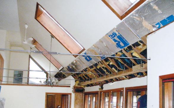 Six steel tie rods connect the horizontal glulam beam at the exterior wall top plate to the floor diaphragm beneath the balcony.