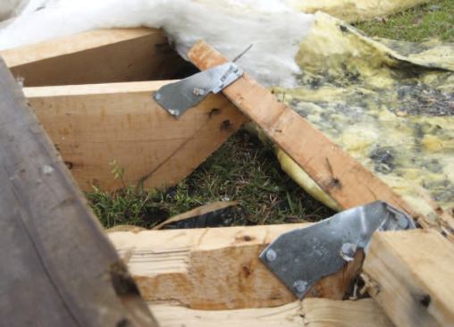 The rafters on another house in the neighborhood were attached with metal connectors; note, however, that the metal ties were nailed to the inside of the top plate. They should have been installed on the outside of the wall, in alignment with the load path through the plywood sheathing.