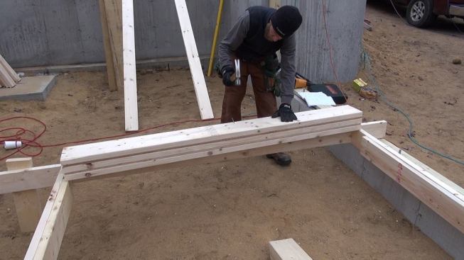Hill sets a triple 2x10 header for the window opening in the new wall.