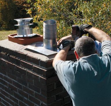 At the top, the liner's cap is set in sealant and screwed in place with masonry screws.