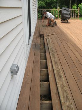 On a low-level deck like this, the best way to assess the ledger-to-house connection is to remove the first few courses of decking.