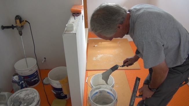 Boucher mixes up a small batch of unmodified mortar, which he'll use to set Kerdi-Band polyethylene joint-sealing membrane over the seams in the Kerdi-Board.