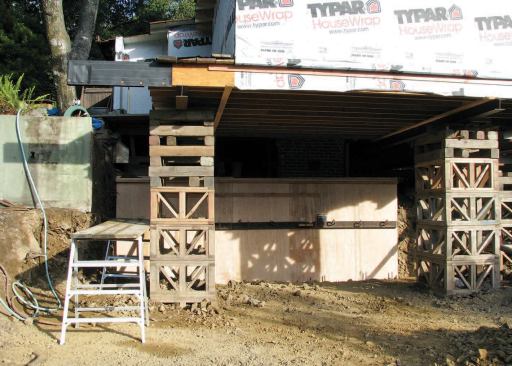 The plans called for extensive digging under the house. To avoid undermining the existing fireplace, which was to be left in place, the crew installed temporary plywood shoring pinned to the earth with heavy rebar.