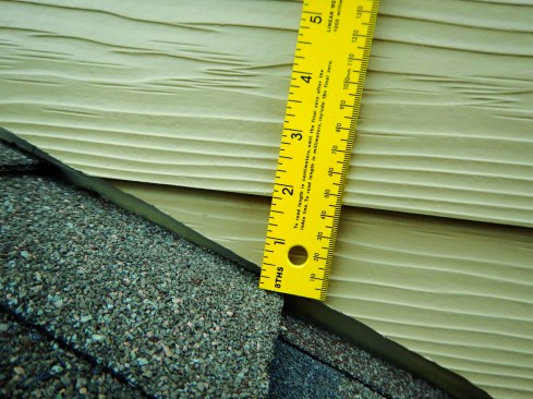The installers brought the siding down onto the roof surface, though there should be 1 inch to 2 inches of clearance for this brand of siding.