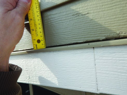The gap above header flashing  should remain uncaulked, but should be at least 1/4-inch. This gap is much too small.