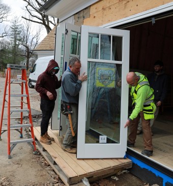 Each door panel is tilted to set the bottom guide into the track.