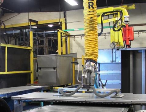 The device coming out of the yellow tube is the business end of a vacuum lifting system; the flat pieces at the ends of the hoses are suction pads. Similar in concept to the vacuum suction cups used to lift glass, this device is connected to a vacuum pump and mechanical hoist. With this system, a worker can lift and position heavy pieces with minimal exertion or risk of injury. I wasn’t able to shoot video of the lift but you can see a different model in 
a video shot by the company that makes the equipment.