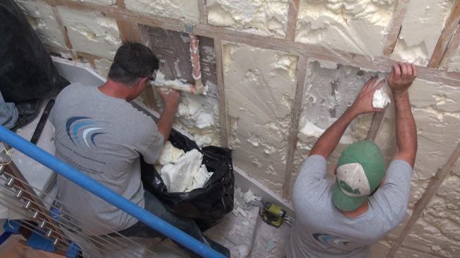 The existing low-density polyurethane foam insulation can be readily pulled out by hand. The crew puts it in plastic bags and takes it out to a dumpster.