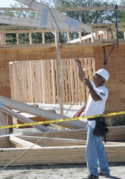 So that work progresses both safely and efficiently, each crew member is assigned a specific task and workstation in accordancewith the company’s safety plan for truss framing. A worker on the ground is assigned the task of hooking trusses up to the crane spreader bar.