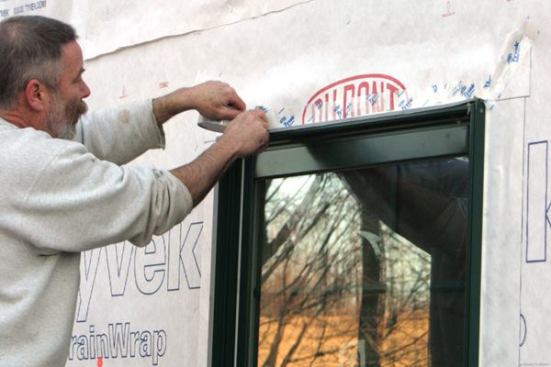 Skip-Tape the Head
I "skip-tape" (apply short pieces of tape with gaps in between) the lower edge of the flap in place. 
Note: These skip-taped gaps act as weeps, giving any moisture that gets to the window head a way to escape.