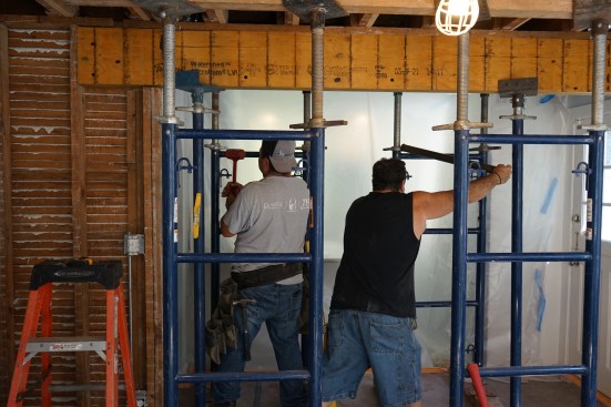 Undermount beam. Ernesto and Toby lift the beam into place, and snug up the shoring to hold it in place.