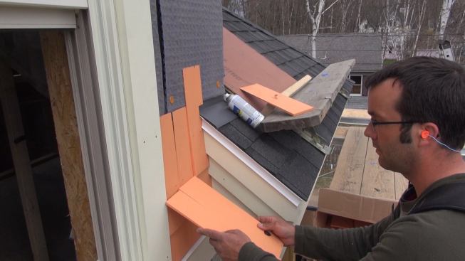 Pollard compares shingle widths to the existing shingle gap as he selects pieces to fill out the course.