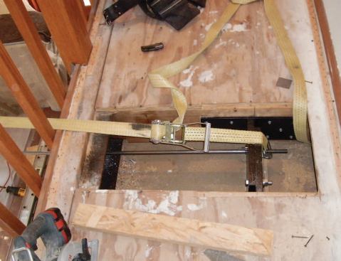 Because the weight of the roof was being carried by scaffolding, nylon ratchet straps hooked to the steel brackets were sufficient for pulling in the leaning wall.