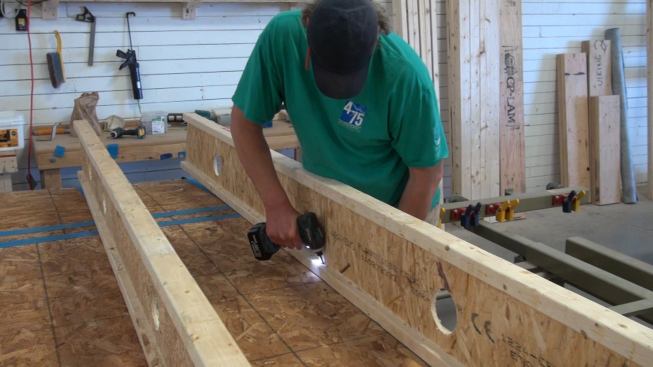 Fastening the I-joist outer wall members to the inner stud wall with structural screws through the OSB structural air barrier and into the studs. ProClima Tescon Vana tape under the I-joists air-seals the screw penetration.