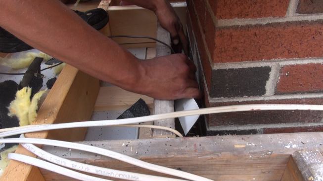 Phillips works the metal into position in the small gap.