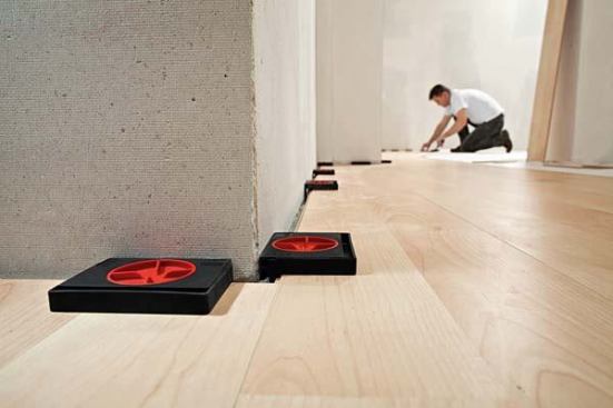 Flooring Spacers. Bessey has introduced a line of installation tools for laminate and hardwood flooring, including strap clamps, wall edge clamps, and adjustable spacers. The AV2 spacers expand with a twist of the central knob to help start your first row of flooring straight and even. They adjust from 5-to 20-mm (about 1/4- to 3/4-inch) and are only marked in millimeters. Price: $12 for a set of four