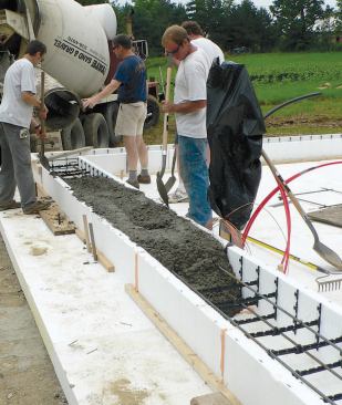 In this alternative to the monolithic slab method, ICFs outline the foundation and are poured first. Forms are stabilized with framing lumber cleats, staked through the foam into the gravel base.