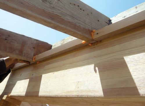 To eliminate air leakage at the ridge, the crew installed blocking between the rafters, sealing it to the framing with spray foam.