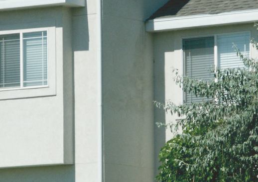 A wall-and-roof intersection built without the correct flashing detail shows discoloration and staining after a few years in service; the author typically finds significant rot in buildings with this detail, even though the wall surfaces may show only minor traces of trouble.