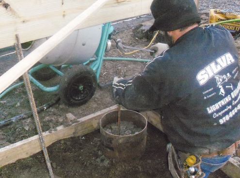Before I place the last 6 inches of concrete, I install three lengths of #4 rebar. I drive them all the way to the bottom of the footing, which should prevent the footing and pier from ever separating.