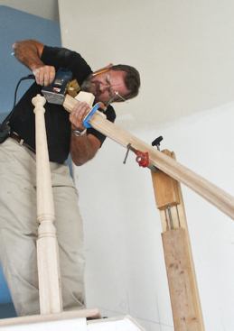 After cutting the miters and fitting the newel post, the author joins the rail sections together with a small biscuit and epoxy.