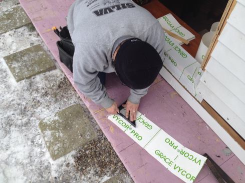 It’s easier to make the cut that will allow the piece of flashing tape to wrap the corner before removing the backing from the tape.
