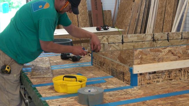 Air-sealing the corners of the inner window buck with ProClima Tescon Vana tape. This integrates the window buck into the wall panel’s air barrier control layer, defined by the taped OSB sheathing.