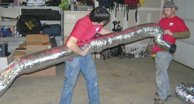 Where a cold-side run of rigid duct is unavoidable, as in a garage, the pre-assembled duct can be slipped inside the foil-faced insulating jacket from a length of flex duct.