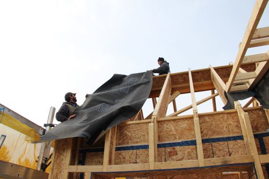 Todd and Caleb drape vapor-open, air-tight and waterproof Mento Plus fabric over the roof-to-wall intersection.
