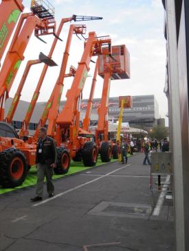 Telehandlers in the parking lot just in front of the central hall of the convention center.