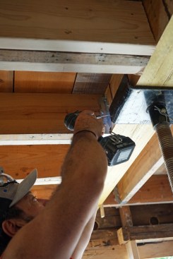 Flush beam. With the beam raised into place, the joists are secured with joist hangers.
