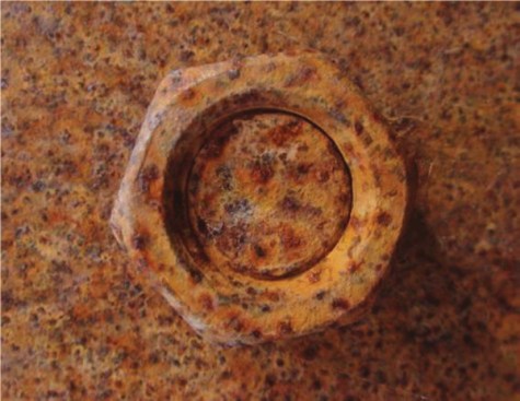 While this mild steel nut exhibits considerable surface corrosion, it is still structurally functional.