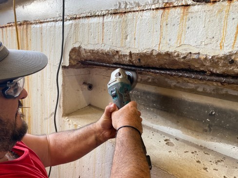 The crew also used a grinder with a flapwheel to remove loose rust from the rebar and burnish the surface in preparation fro painting the steel.