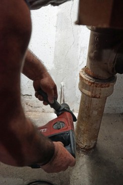 Toby starts at the bottom of the crack drilling a series of 3/8-inch-diameter holes every 8 to 10 inches.  The injection ports will be placed over each of these holes.