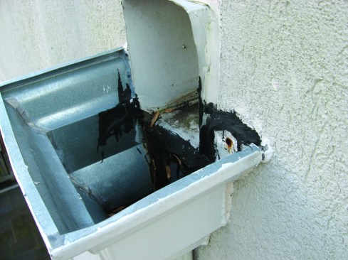 Receptors for the scuppers should be mounted as low as possible on the outside of the parapet so that water can't back up onto the roof if the receptors become obstructed. 