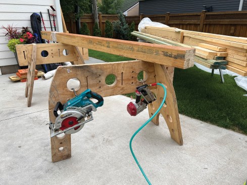 The holes in the rails of the author’s “Tri-horse” sawhorses reduce the weight but also serve as places to hang and hold tools.