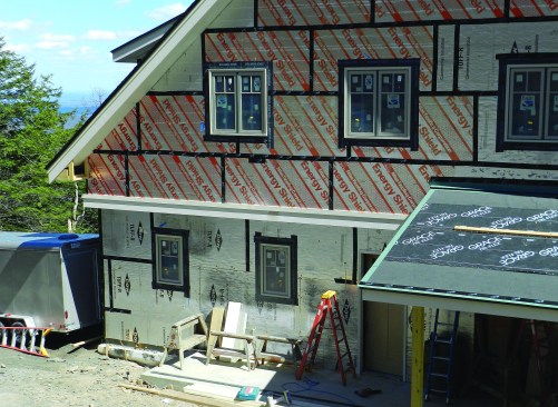 A critical element in the process of installing the polyiso is to seal all the joints. We used Zip System tape, which of all the tapes we’ve used had the greatest ability to stick to the foil facing. Before applying the tape, though, we had to wipe off the foil surface with lacquer thinner to remove an oily residue left from the manufacturing process. Below grade on the side and front of the house, we used a Delta-Dry system to create drainage against the ICF (insulated concrete form) foundation and flashed the top edge with Soprema—a peel-and-stick membrane recommended by the ICF manufacturer. It’s critical to use materials that are compatible.