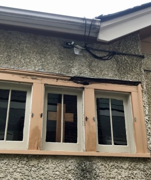 Water highway. The rot on this window head occurred because an ice-melt wire, which ran down a valley and was plugged in under the eaves, created a “water highway” that soaked the wood. Surface tension caused the water to cling to the wire and travel along it until it drained off the dip just over the window.