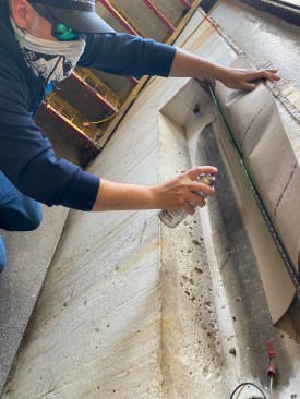After masking off the concrete and wire brushing the steel, the author painted the rebar with an epoxy paint.