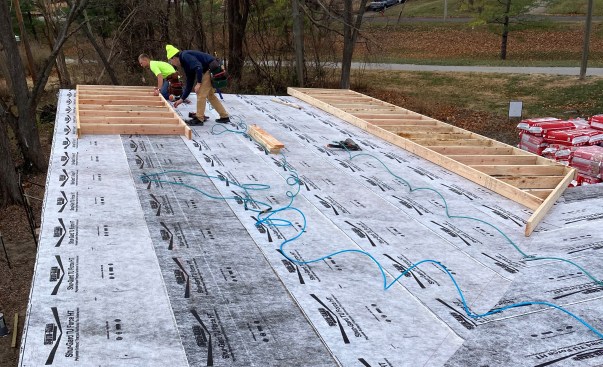 Having completed the truss roof assembly (the “underroof), the framing crew built ladder sections that would cantilever over the building line to create the narrow fascia essential to the Midcentury-Modern look. 