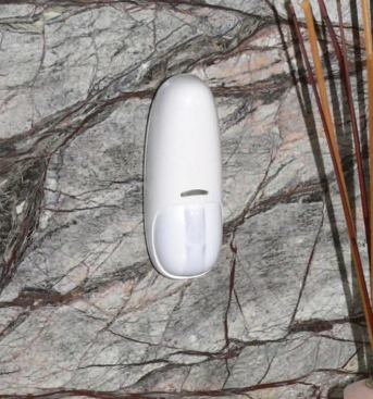 This wireless motion-detector switch is attached to a bathroom backsplash.