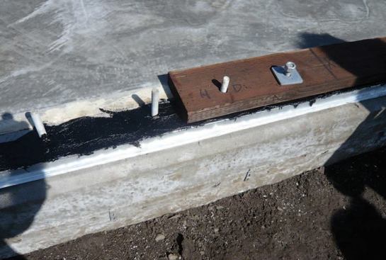 For air-sealing the frame to the slab, the mudsills were bolted in place in a bed of roofing cement.