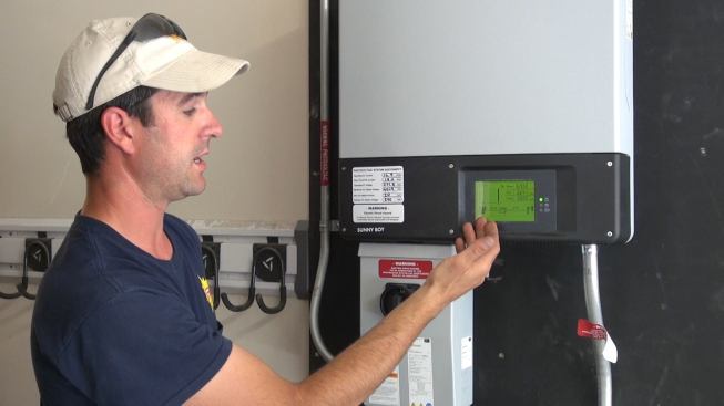 Once Bernard has flipped the disconnect switch to energize the inverter, and flipped the breaker in the house electrical panel to connect the system to the AC house power, the inverter goes through its start-up check routine and begins to send power to the house. The green readout on the inverter indicates that the system has begun supplying 3,200 watts (about 3 kilowatts) to the house.