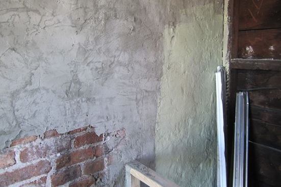 Here, a section of brick party wall has been partly covered with a parge of wet lime mortar slurry, and partially coated with a water-repellent and air-tight, but vapor-open, coating of Sto Emerald Cote. The entire wall will be parged and coated to create a continuous “air control layer” between the occupied space and neighboring buildings or the outdoors.