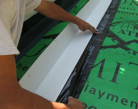 Then he bonds the sticky faces of the two pieces of flashing tape together.