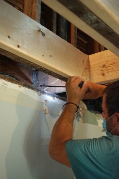 Ernest secures metal clips to the new header using structural screws made by Simpson Strong Tie. 