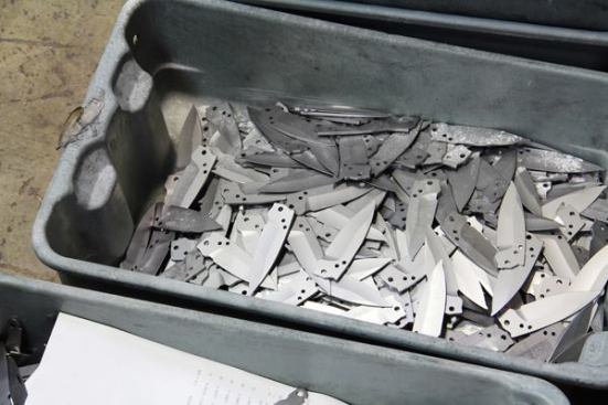 These knife blades have been roughly ground to shape, heat-treated, and bead blasted—in preparation for further grinding and then final sharpening.