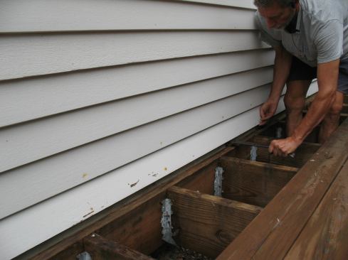 The clapboards above the ledger had to be carefully pried away from the siding so the author could install new flashing.