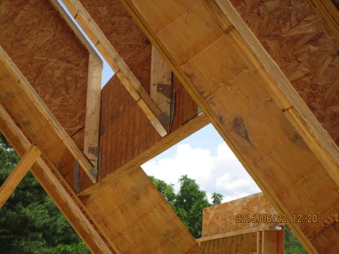 An LVL header supports the lower end of two wood I-joist cripple rafters to create a dormer opening in the roof frame.